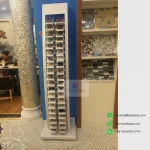White mosaic tile floor display rack in a client showroom with samples on display